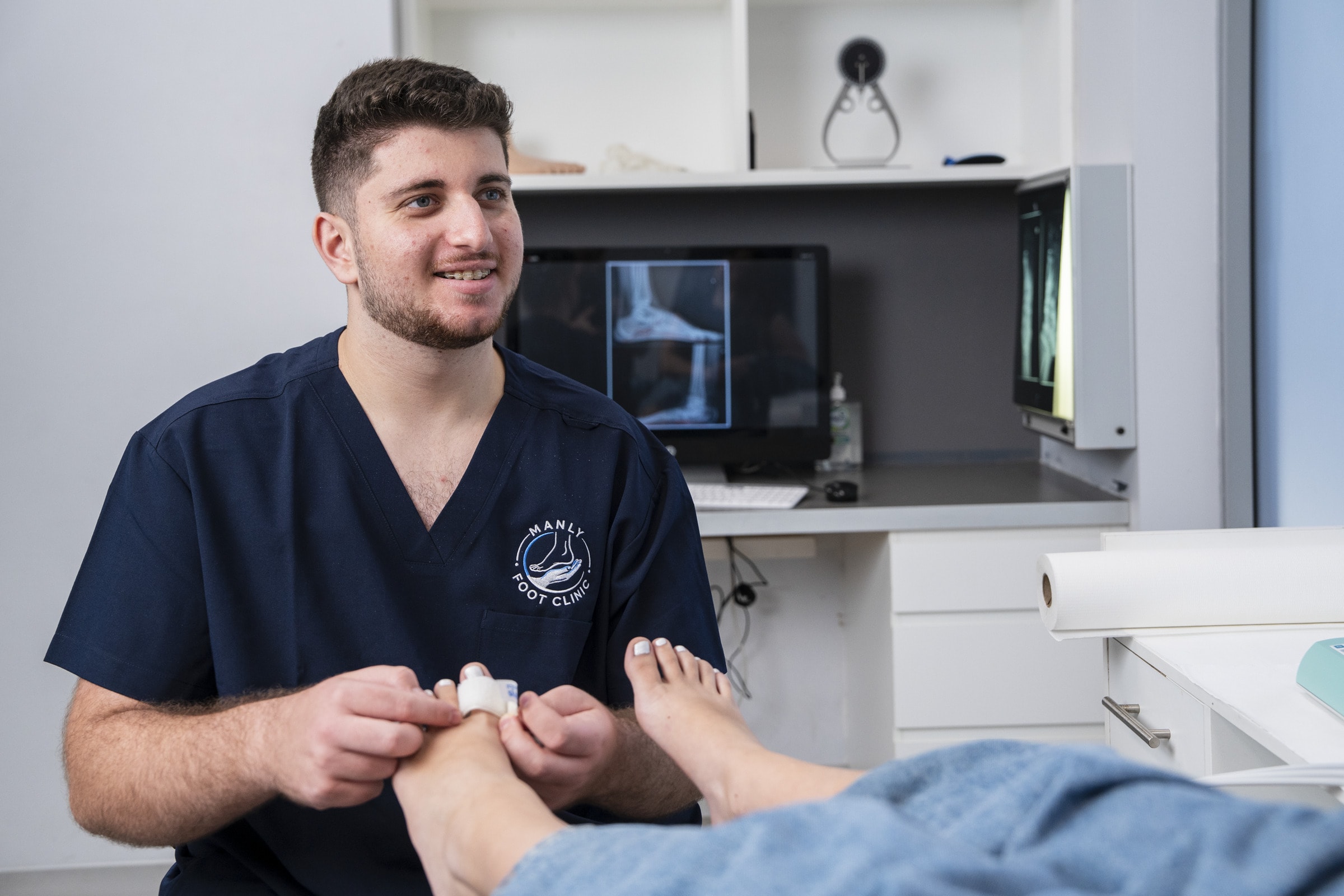 A podiatrist treating a patient’s toe at Manly Foot Clinic